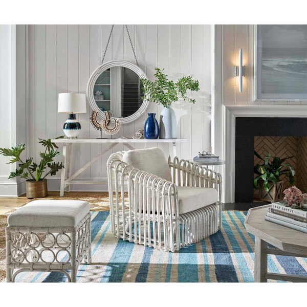 Living room corner with a white chair, ottoman, and glass lamp